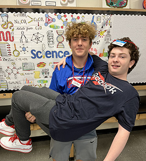 Two students in front of a science bulletin board