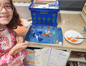 Student proudly showing off her science project