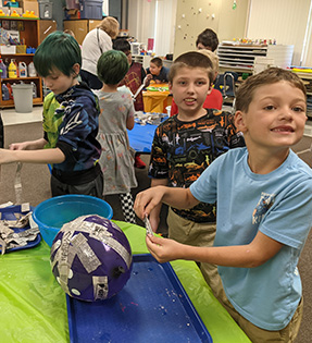 Group of kids working on a papier mache project