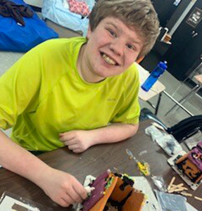 Close up of student in yellow t-shirt at his desk