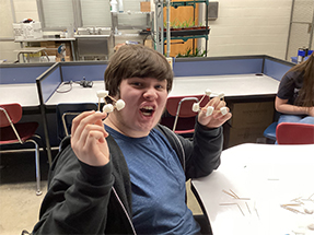 Boy in classroom having fun with a marshmallow project