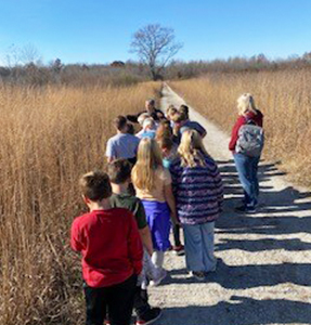 Group of students walking on a trail outside
