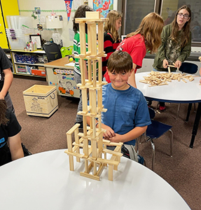 Young boy building a tall structure with building blocks