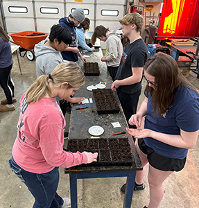 Students planting seeds on a large table