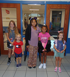 five students standing in hallway