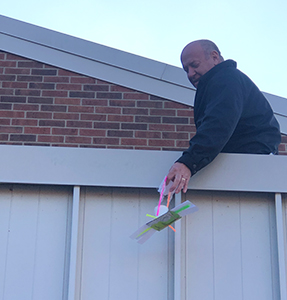 Man holding paper airplane from a upper deck